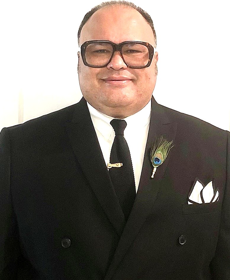 Portrait in a black suit with a peacock feather boutonniere